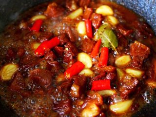 18、红烧牛肉炖大蒜,加入小米辣烧开即可关火。