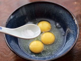 3、泡菜炒鸡蛋,再加入盐调味。