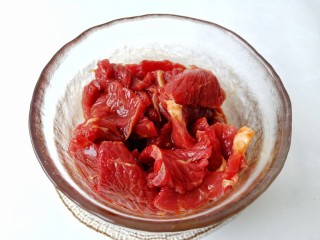 7、爆炒牛肉丝,带上手套把牛肉抓匀，这样才会更入味。再淋一勺食用油抓匀，锁住调味料和水分，腌制 15 分钟。