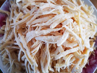 8、凉拌鸡丝,将胡萝卜丝和黄瓜丝放在盘中垫底，再把撕好的鸡丝放在上面