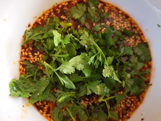 13、凉拌鸡丝,将切好的蒜和香菜放入调料碗中