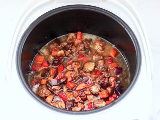 13、懒人版鸡翅香菇焖饭,上面倒入炒熟的食材,把泡发香菇的水倒入。