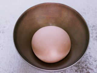 10、酸菜猪肉粉嫩饺子,和好的面团用手揉圆后，放入一个容器里，盖上保鲜膜静置一会儿。