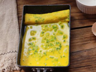 11、香葱肉松厚蛋烧,倒入1/3蛋液，小火继续煎