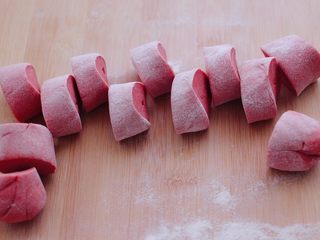 9、粉嫩蔓越莓果仁芝麻饼,把醒发好的面团排气揉匀后，用手搓成长条，用刀切成大小一致的剂子。