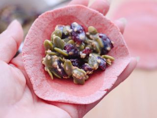 11、粉嫩蔓越莓果仁芝麻饼,擀好的面皮上，放入适量的馅料，和平常包包子一样包紧就可以了。
