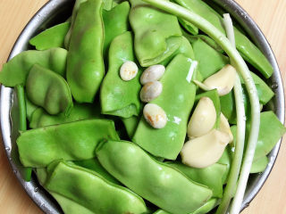 9、排骨豆角焖面,将豆角去蒂、掰成两半，小葱和蒜切成末。