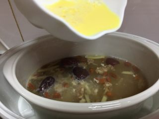 6、醪糟经期补血粥,鸡丝熬煮30分钟以后放入蛋黄液均匀淋在上面。继续熬煮30分钟。然后闷10分钟。