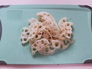 6、藕片爆桃花蛸,把洗净的藕从中间切开后,再切成薄片。