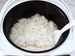 3、香椿红虾饭团,启动煮饭模式煮熟米饭,把煮熟的米饭用锅铲打散放凉备用。