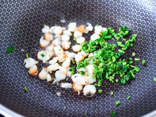 8、香椿红虾饭团,锅烧热后倒入花生油烧热,放入一半的红虾碎和香椿的茎。