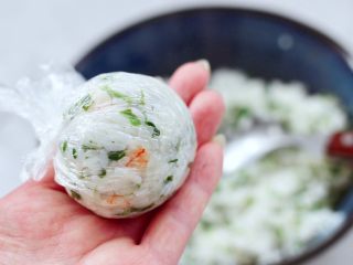 15、香椿红虾饭团,借助保鲜膜团成圆团。