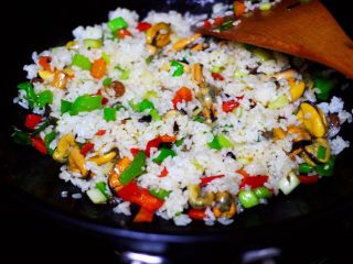 14、海虹蒜苗什锦蛋炒饭,把倒在锅中的米饭打散后,和所有的食材混合翻炒均匀后。