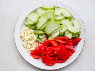 2、佛手瓜炒腊肉,佛手瓜去籽切成薄片，大红椒切滚刀块，大蒜切碎。