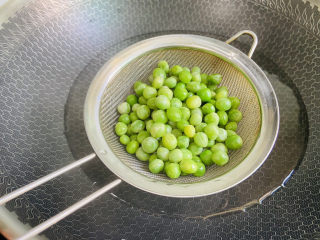 5、豌豆炒虾仁,锅中加入清水大火烧开放入豌豆粒焯烫片刻捞起沥干水分
