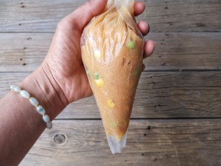 11、宝宝香肠,将肉糜放进裱花袋中,把裱花袋的尖端斜着剪一个开口。