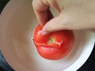 3、番茄肥牛卷,烧点热水,将番茄在水中翻滚一下。