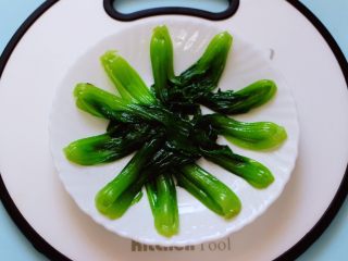 11、时蔬烩虾球,焯好的小油菜捞出沥干水分后，码放在盘子里。