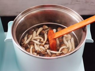 5、蟹味菇爆花肉,东菱早餐机的汤锅里，加入适量的清水煮沸后，把蟹味菇进行焯水，焯过水的蟹味菇捞出沥干水分。