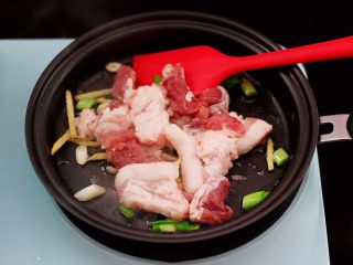 6、蟹味菇爆花肉,平底锅倒入花生油烧热后，先爆香葱姜后，放入切片的五花肉。