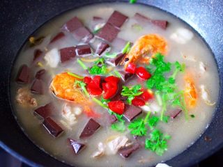 17、肉片海虾烩猪血,加入红椒碎和香菜，即可关火。