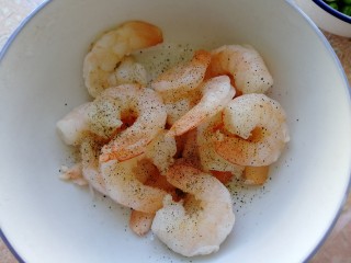 3、玉米炒虾仁,洗净的虾仁用厨房纸巾吸去水份，放入少许盐和黑胡椒粉，抓匀腌制几分钟。