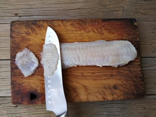 2、蒜蓉粉丝蒸鱼片,将龙利鱼用斜刀片成鱼片。