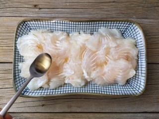 3、蒜蓉粉丝蒸鱼片,在片好的鱼片中加适量料酒抓拌均匀腌制10分钟。