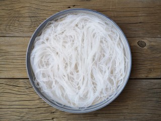 8、蒜蓉粉丝蒸鱼片,将泡好的粉丝沥水后平铺在盘中。