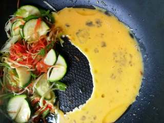 9、月半弯炒（拌）面,把快要炒好的食材请至一旁，已搅拌均匀的鸡蛋液下锅，大约6成凝固后，就可于其他食材一起翻转了。未凝固的少许蛋液，也略有不同的口感。