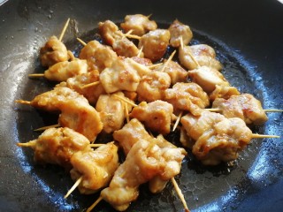 15、牙签肉,翻面，文火慢煎，煎至肉质收缩，整体焦黄，盛出备用。