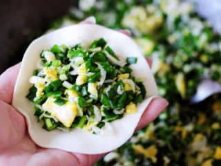 9、百吃不厌的韭菜盒子,把擀好的面皮里放入适量搅拌好的馅料。