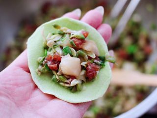 14、槐花扇贝肉丁翡翠饺子,擀好的面皮放入适量的馅料。