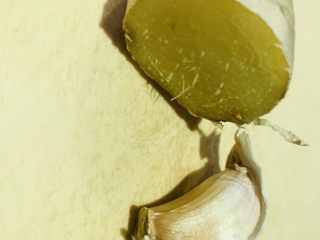 2、干煸牛肉丝,准备半块姜和一瓣蒜头洗净，蒜头去皮；