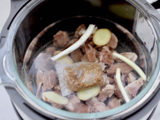 8、牛腩炖萝卜,放入炖牛肉调料包，剩下的葱和姜片，倒入不超过水位线的清水。