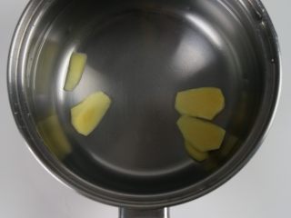 3、排骨板栗香焖饭,锅里倒入适量的水,加入姜片。