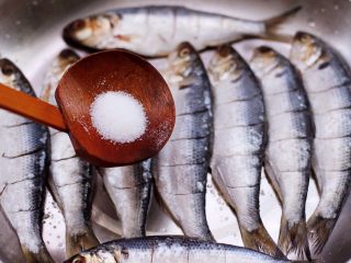 7、干炸海鲫鱼,依次把所有的海鲫鱼都改好刀，再根据个人口味加入适量的盐调味。