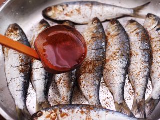 9、干炸海鲫鱼,倒入料酒去腥。