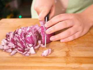 4、法式香橙煎鸭胸 ,将洋葱旋转90℃,从水平的方向平切洋葱,再垂直向下切成洋葱丁。