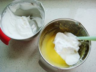 11、原味戚风蛋糕（8寸基础戚风超详细版）,把打好的蛋白分一半倒入蛋黄糊糊里。