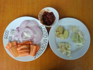 4、鲜香麻辣章鱼足,洋葱切丝，红萝卜切片，姜切片，葱切断，拍松，大蒜用刀拍松，郫县豆瓣酱剁碎。