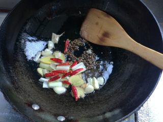 6、鲜香麻辣章鱼足,锅坐火上，热锅凉油，下姜片，葱段，蒜瓣炒香，下入干辣椒、麻椒煸炒出香味。