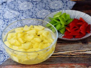 2、菠萝咕噜肉,菠萝削皮切成小块，放入淡盐水中浸泡备用，防止氧化变色，青红椒去籽洗净切小块