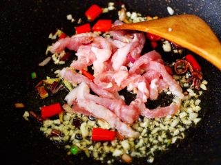 5、五花肉醋溜绿豆芽,锅烧热倒入花生油烧热后，放入洋葱爆香，再放入大蒜末炒香，加入小米辣和五花肉。