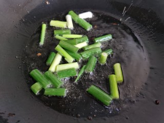 7、清炒南瓜丝,放入葱段翻炒。