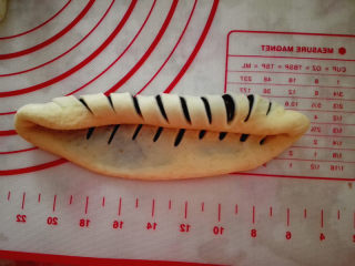 7、黑芝麻面包圈,从一端慢慢卷起，卷成长条状，再把两头弯到一起，形成一个圆圈，接口处捏紧，