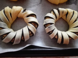 8、黑芝麻面包圈,烤盘上铺上油纸，将整好形的面包放在上面，