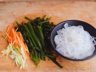 5、肉末海带炒粉条,把焯过水的海带用清水冲洗一下后用刀切成丝，胡萝卜切丝，葱姜切丝，粉条沥干水分备用。