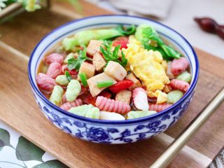 18、鸡蛋西红柿打卤面,做好的彩色贝壳面倒入碗里，上面浇上做好的卤菜就可以享用了。