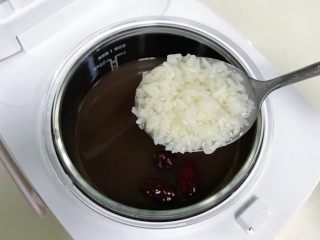 6、红豆薏米甜酒酿,炖煮剩余5分钟时候加入3～4勺的甜酒酿和2块冰糖或红糖。